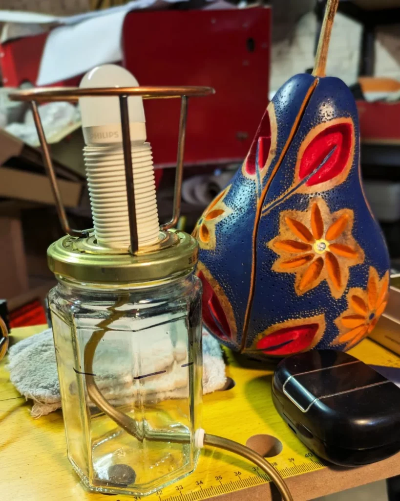 Les composants d'une MagiCalBass : pied avec système électrique fixé, pièce de carcasse d'abat-jour et abat-jour