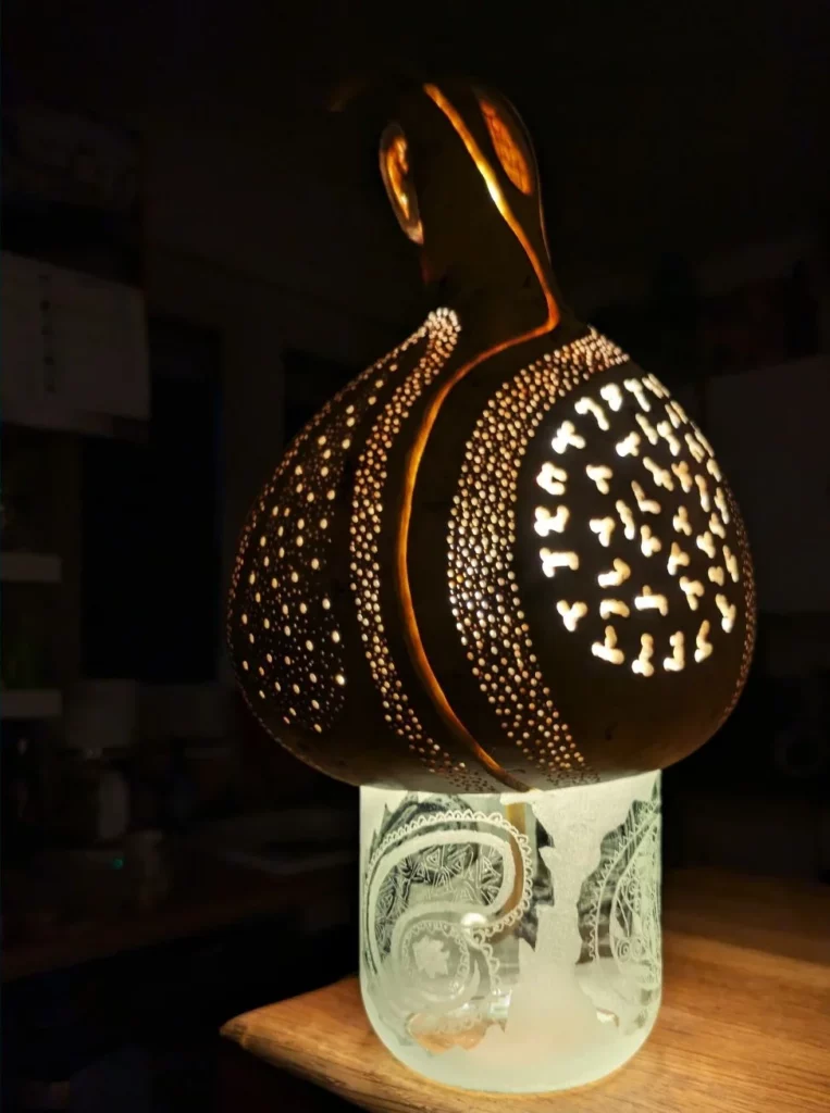 Lampe Pleasure Drop de nuit allumée sur planche de bois